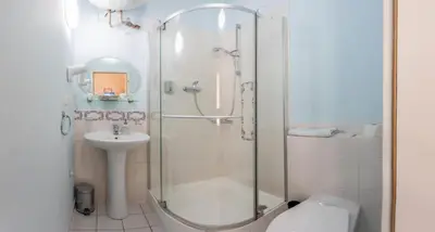 a bathroom with a shower and a toilet and a sink at Loreta Hotel in Prague