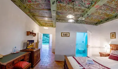 a bedroom with a ceiling with a painting on it at Loreta Hotel in Prague