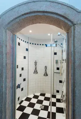 a bathroom with a black and white checkered floor at Loreta Hotel in Prague