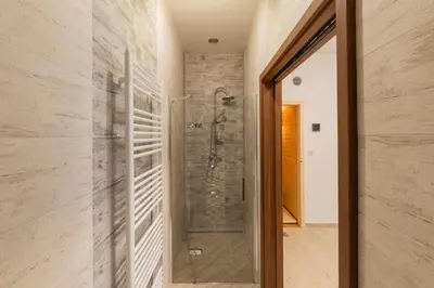 a bathroom with a shower and a glass door at Penzion Piranha in Mělník