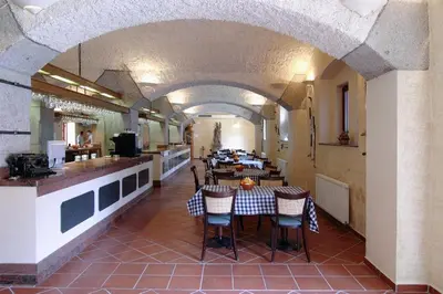 a restaurant with a table and chairs in a room at Golf Resort Hotel Konopiště in Benešov