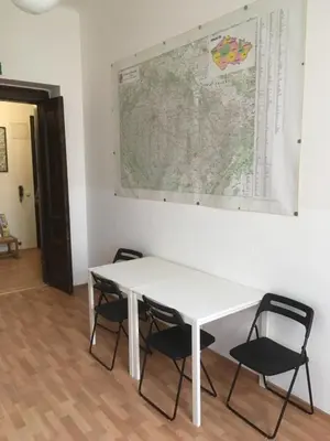 a white table with chairs and a map on the wall at Hostel EMMA in Prague