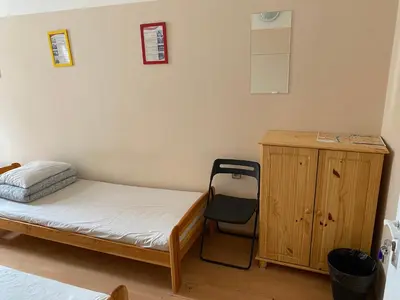 a bedroom with a bed and a desk and a chair at Hostel EMMA in Prague