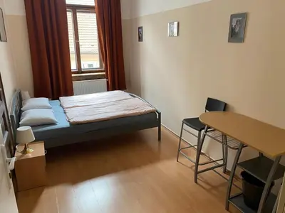 a small room with a bed and a table at Hostel EMMA in Prague