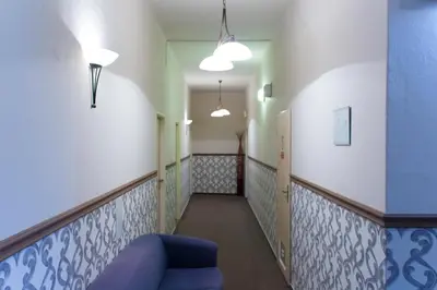 a hallway with a blue couch in a room at Hotel Soudek in Poděbrady