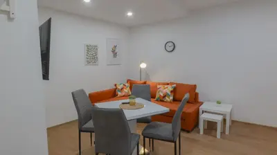 a living room with a couch and a table and chairs at Krakovka Residence in Prague