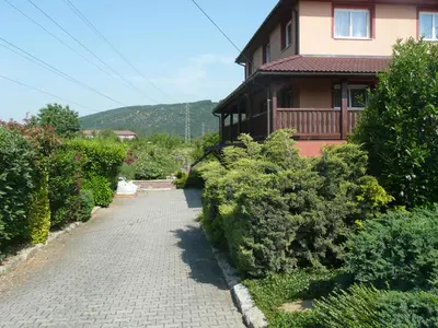 a house with a brick walkway next to a building at Penzion U Tulaka in Dobřichovice