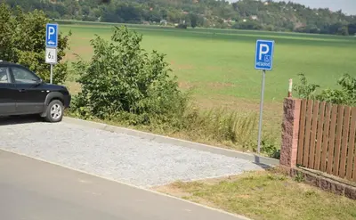 a car parked on the side of a road with parking signs at Penzion U Tulaka in Dobřichovice