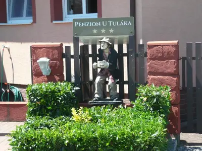 a statue of a man sitting on a fence at Penzion U Tulaka in Dobřichovice