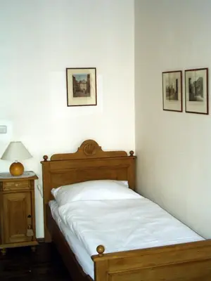 a bedroom with a bed and a table with a lamp at Villa Olivia in Prague