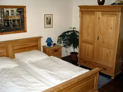 a bedroom with a large bed and a wooden cabinet at Villa Olivia in Prague