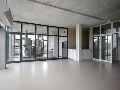 an empty room with large glass doors and a kitchen at Pivotel MMX in Dobřichovice