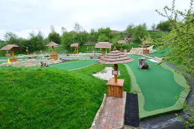 a miniature golf course with a green field and umbrella at Resort Svět in Úžice