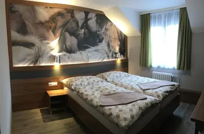 a bedroom with two beds and a large painting on the wall at Hotel U koně in Beroun