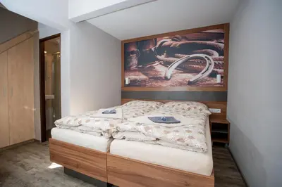 a bedroom with a bed with a painting on the wall at Hotel U koně in Beroun