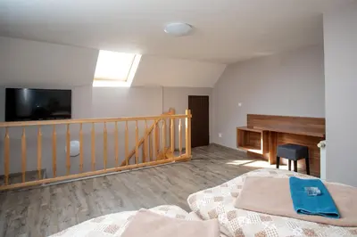a bedroom with a bed and a tv and a desk at Hotel U koně in Beroun