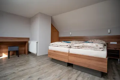 a bedroom with a large bed and a desk at Hotel U koně in Beroun