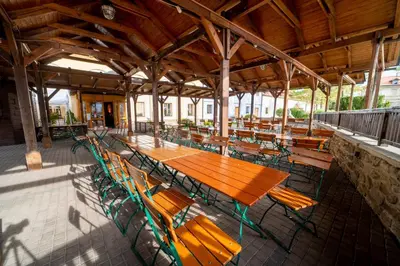 a cafeteria with a wooden table and chairs at Hotel Čertousy in Prague