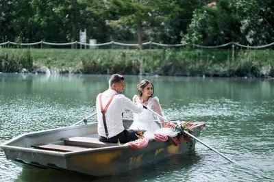 a bride and groom in a row boat on the water at Hotel Čertousy in Prague