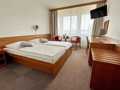 a hotel room with a bed and a desk at Hotel ILF in Prague
