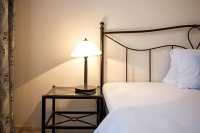 a lamp on a glass table next to a bed at Residence Hattrick in Prague