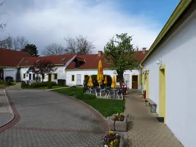 a building with chairs and umbrellas in a courtyard at Český Statek in Prague