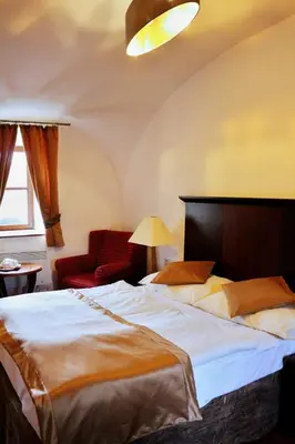 a bedroom with a large bed and a red chair at Český Statek in Prague