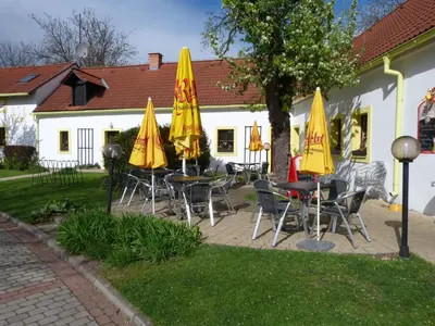 a group of tables and chairs with yellow umbrellas at Český Statek in Prague