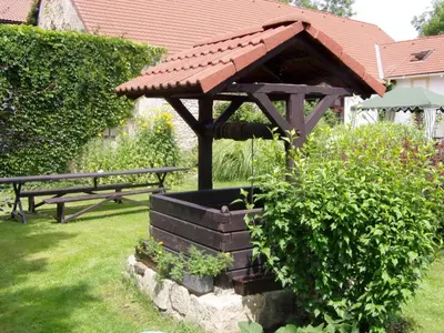 a wooden gazebo with a fountain in a garden at Český Statek in Prague