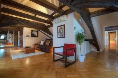 a living room with a red chair and a couch at U Kapra Apartments in Prague