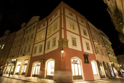 a large building is lit up at night at U Kapra Apartments in Prague