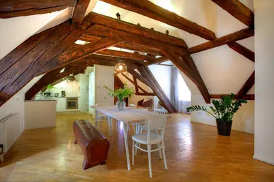 a dining room with wooden ceilings and a table and chairs at U Kapra Apartments in Prague