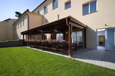 a covered patio with tables and flowers in a building at Dolce Villa in Prague