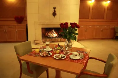 a dining room table with a vase of flowers and a fireplace at Dolce Villa in Prague