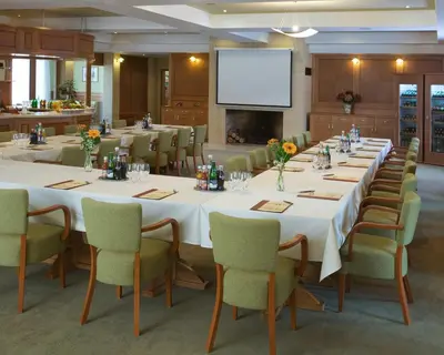 a conference room with tables and chairs and a screen at Dolce Villa in Prague