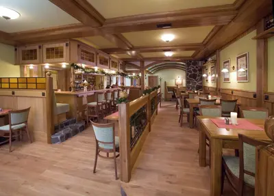 a restaurant with wooden floors and tables and chairs at Dolce Villa in Prague