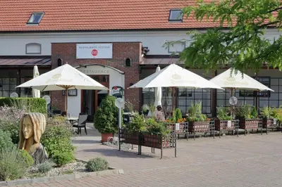 a patio with tables and umbrellas in front of a building at Hotel Chvalská Tvrz in Prague