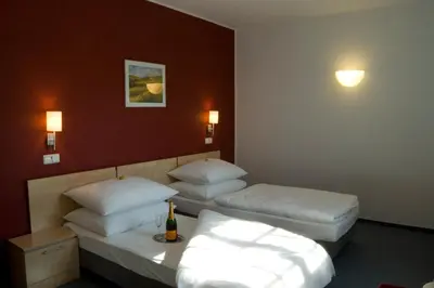 a hotel room with two beds with white pillows at Hotel Chvalská Tvrz in Prague