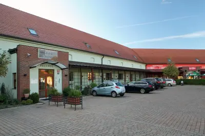 a building with cars parked in a parking lot at Hotel Chvalská Tvrz in Prague