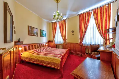 a bedroom with a bed and a table and windows at Betlem Club Hotel in Prague