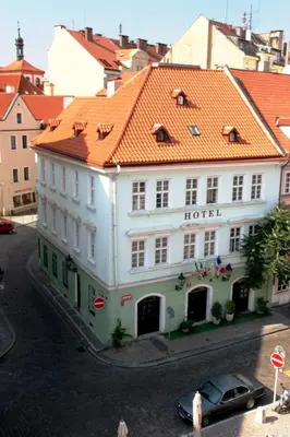 a white hotel with an orange roof on a street at Betlem Club Hotel in Prague