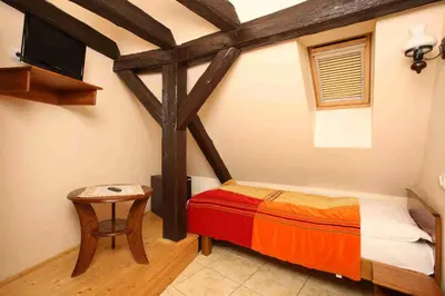 a room with a bed and a tv and a table at Betlem Club Hotel in Prague