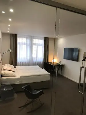 a bedroom with a bed and a chair and a television at Rozmaryn Hotel B&B in Rakovník