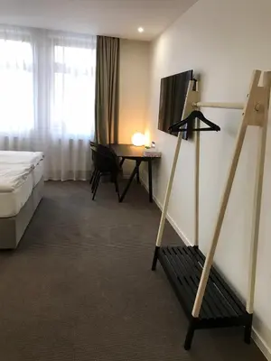 a hotel room with a bed and a desk with a table at Rozmaryn Hotel B&B in Rakovník