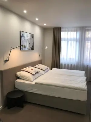 a bedroom with a large bed with white sheets at Rozmaryn Hotel B&B in Rakovník