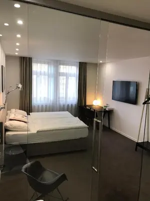 a bedroom with a bed and a television and a chair at Rozmaryn Hotel B&B in Rakovník
