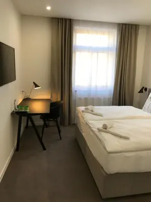 a hotel room with a bed and a desk with a computer at Rozmaryn Hotel B&B in Rakovník