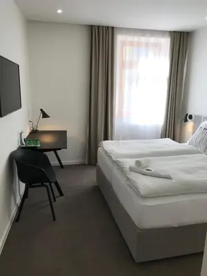 a hotel room with a bed and a desk at Rozmaryn Hotel B&B in Rakovník