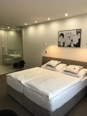 a bedroom with a large white bed with a mirror at Rozmaryn Hotel B&B in Rakovník