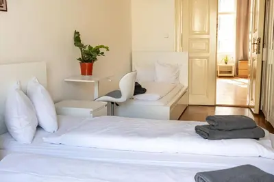 a bedroom with a white bed and a chair at Apartments in Mala Strana - 10 minutes from Charles Bridge in Prague